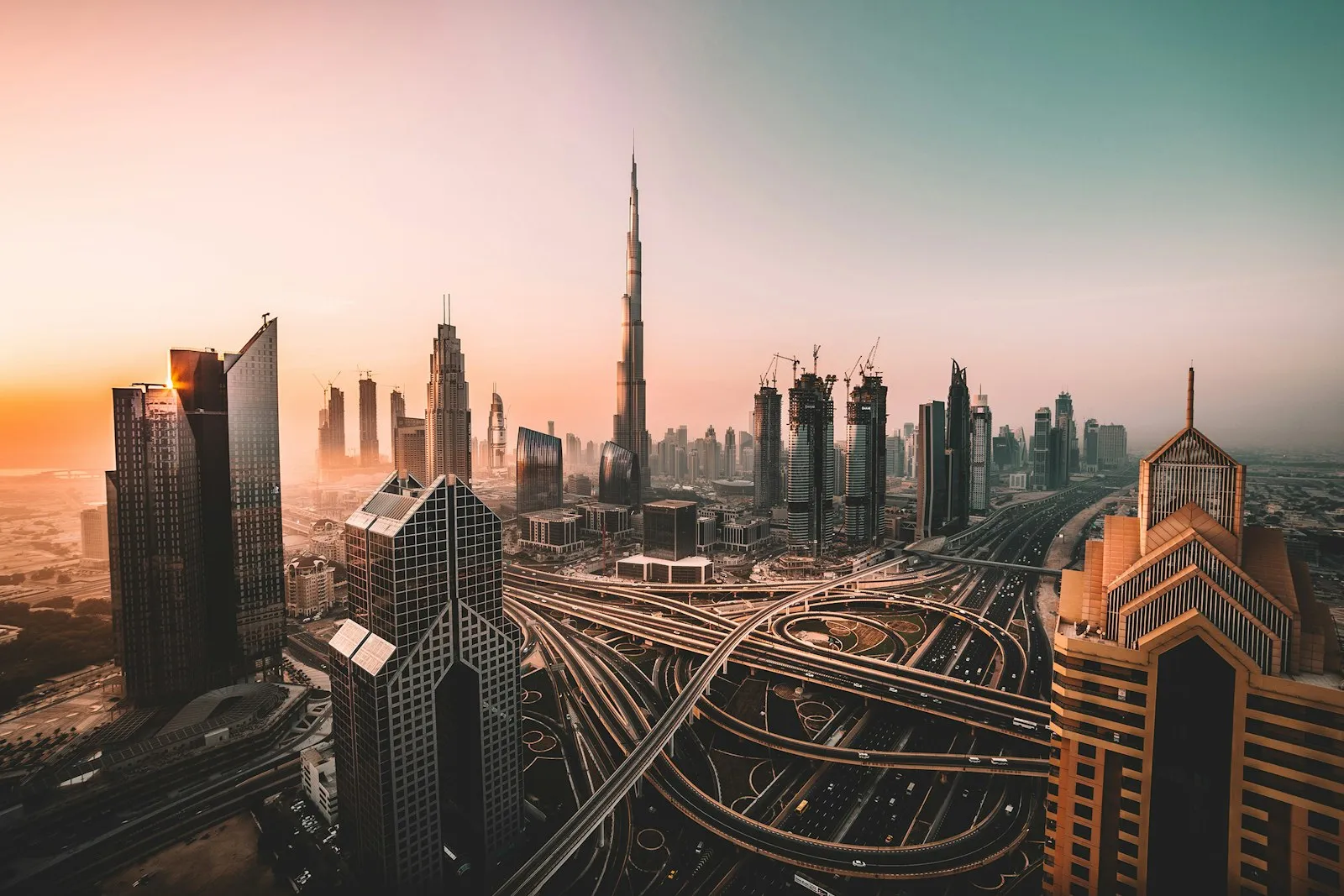 Dubai skyline and the Burj Khalifa at sunset above a web of highways