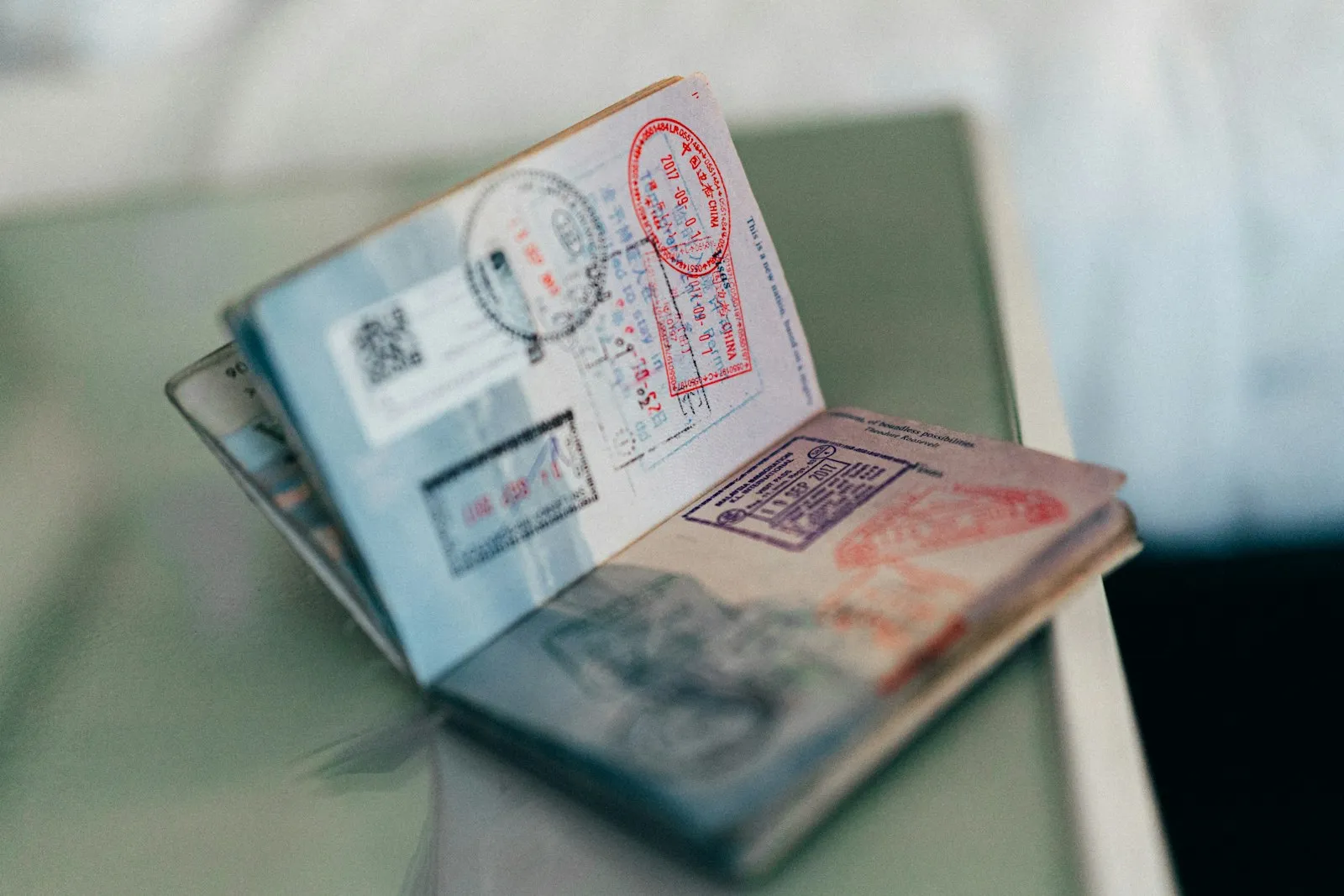 An open passport with multiple colourful ink travel stamps