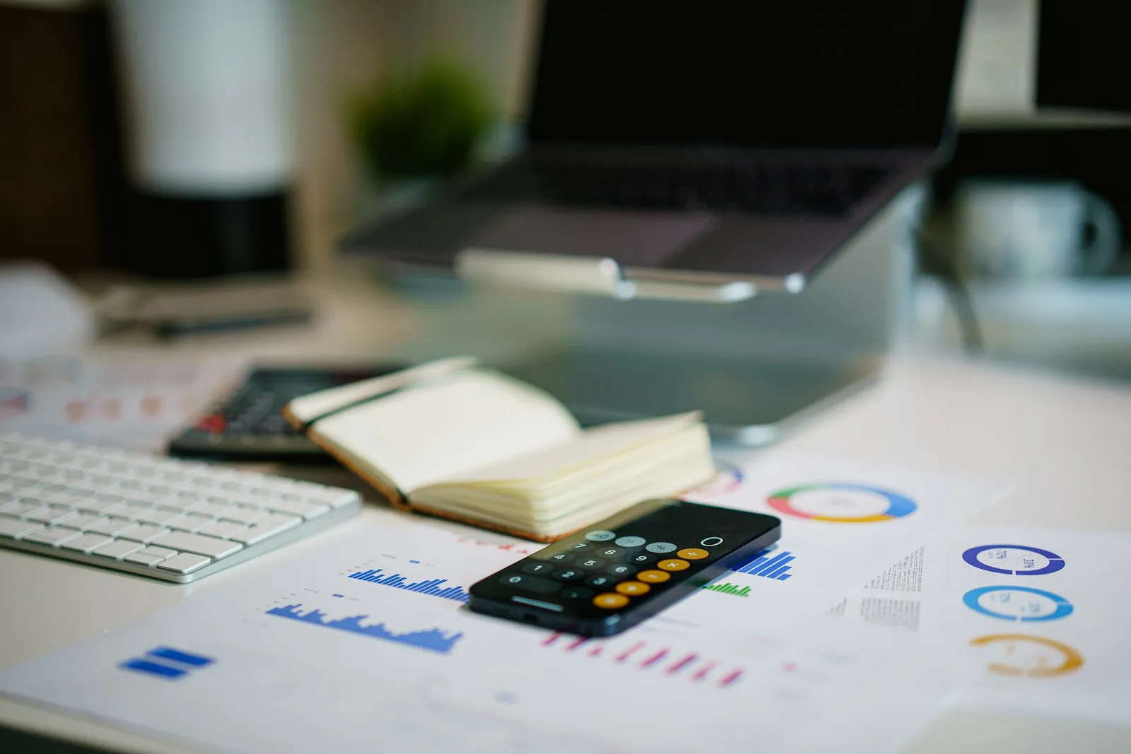 Office desk with a smartphone showing financial charts